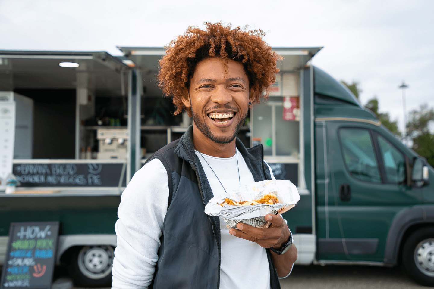 Smiling customer with food outside a food truck